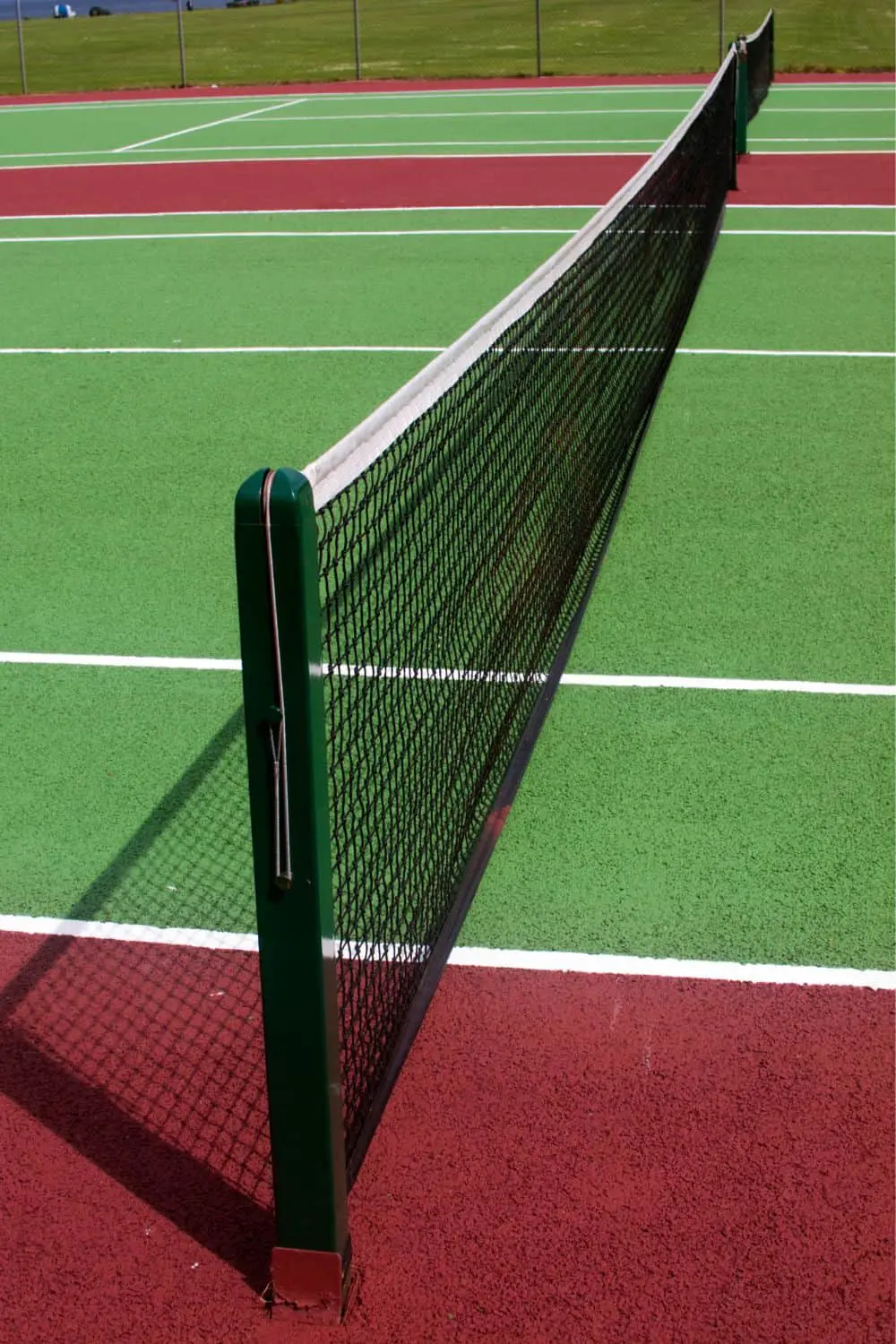 close up of a tennis net, with a synthetic grass court in the background that has just been installed by Surprise Artificial Grass Co