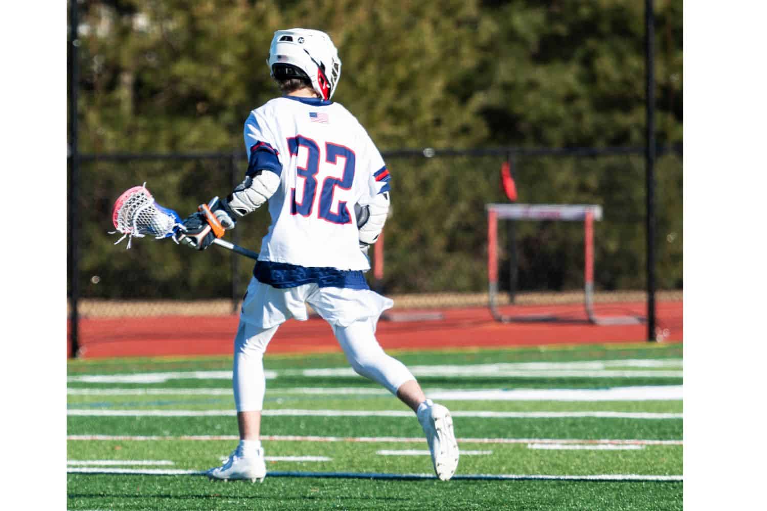 a lacrosse player running across a synthetic turf playing field in Surprise Arizona